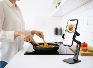 Phone holder clamped to kitchen counter holding phone with recipe displayed